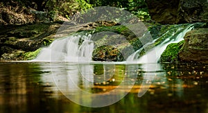 Pool with Waterfall and Running Water between rocky mountains