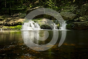 Pool with Waterfall and Running Water between rocky mountains