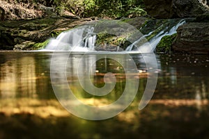 Pool with Waterfall and Running Water between rocky mountains