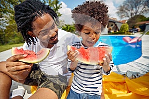 Poolside Bonding: Father and Son Enjoying Watermelon