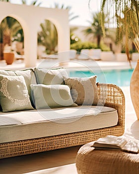 Poolside lounge are with rattan sofa with ornaments pillows. Beautiful hotel spa or wellness concept, recreational vacation resort