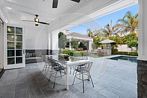 Poolside patio with outdoor dining table in a new construction home in Encino, California