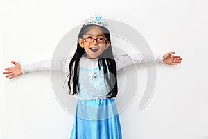 Poor 4-year-old Latin brunette girl is dressed as a happy princess with her costume to go to a children`s party and feel strong an