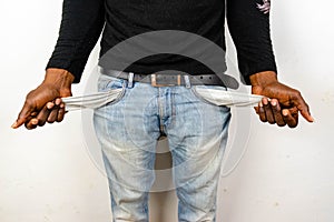 Poor African American Black man in jeans with empty pocket. for broke concept photo