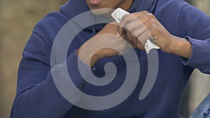 Poor african-american teen guy counting money in palm outdoor, life difficulties