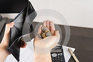 Poor Asian man hand open empty wallet and holding coins looking for money having problem bankrupt broke after credit card payday.