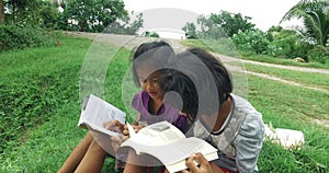 Poor Asian Thai girl reading and studying alone and her friend join in for study.