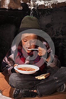 Poor beggar child eating charity food