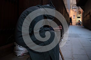 A poor beggar man in traditional Moroccan hoody djellaba outfit. fokiya, jellaba. Anonymous poor beggar in the street photo
