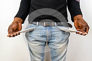 Poor Black man in jeans with empty pocket. Nigerian African American Man showing empty denim pockets on white background for joble