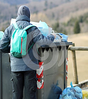 poor boy looks for something to eat in the rubbish bin