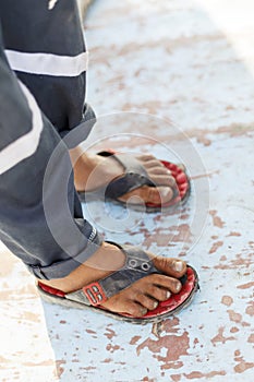 Poor boy wearing flip-flops