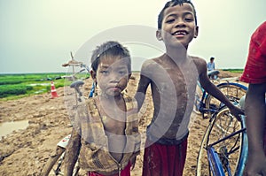 Poor cambodian kids playing with bicycle