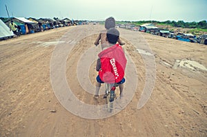 Poor cambodian kids racing with old bicycle