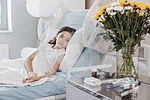 Poor child with drop counter lying on hospital bed