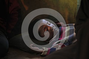 Poor child sleeping on grandparents house floor.