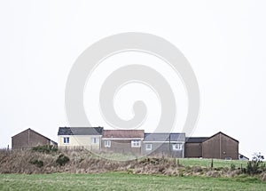 Poor council houses on cliff horizon in seaside town by coast