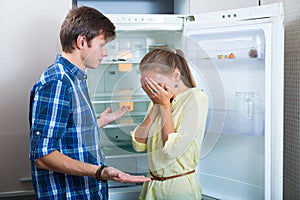 Poor couple near empty fridge