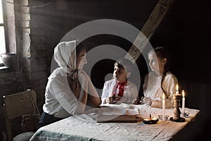 Poor family at the table. Mother gave the children the last piece of bread