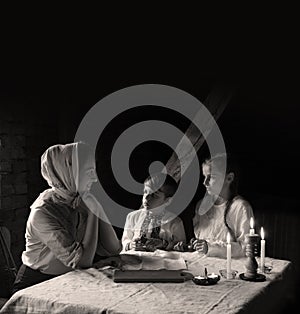 Poor family at the table. Mother gave the children the last piece of bread