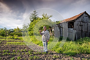 Poor farmer hoeing vegetable garden
