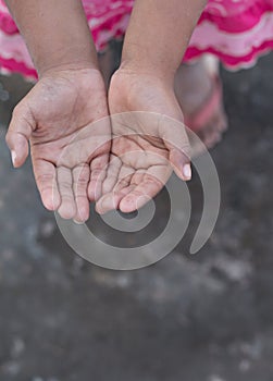 A poor girl raising hands beg for some food or some money in poor life concept