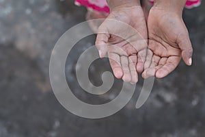 A poor girl raising hands beg for some food or some money in poor life concept