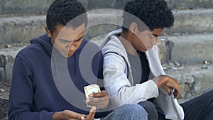 Poor homeless african american male friends counting money, unemployment