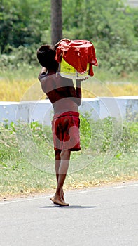 A Poor Homeless Boy Carrying drinking water