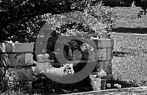 Poor homeless man sleeping on the wooden bench in the park.