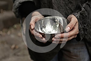 Poor homeless woman with empty bowl, closeup