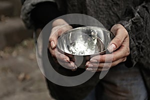 Poor homeless woman with empty bowl, closeup photo
