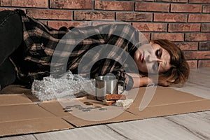 Poor homeless woman lying on floor