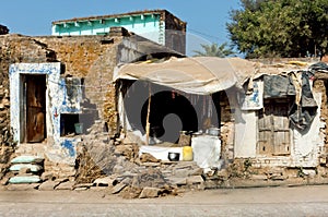 Poor indian family house with broken walls on dirty street