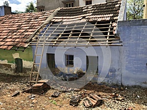 Poor indian house with broken tiles with wooden beam