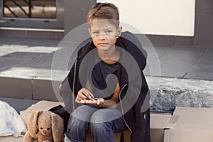 Poor little boy counting coins on street