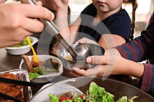 Poor little children receiving food from volunteer in charity centre