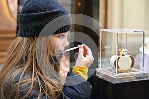 Poor little girl sniffs perfume