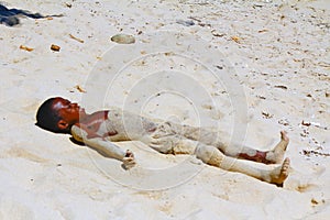 Poor malagasy boy playing on the beach