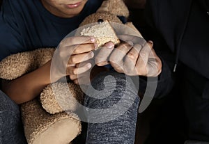 Poor man giving piece of bread to his son