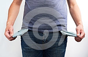 Poor man in jeans with empty pocket. No money concept