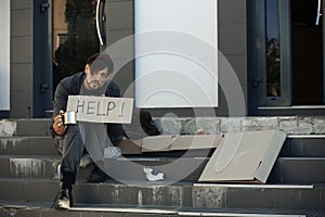 Poor man with mug begging and asking for help