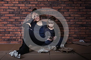 Poor mother and daughter sitting on floor