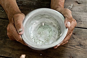 The poor old man& x27;s hands hold an empty bowl of beg you for help.