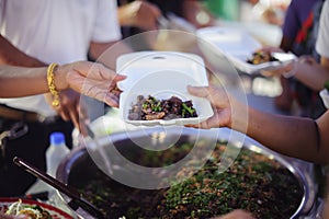 Poor people receiving food from donations : Homeless people are helped with food relief, famine relief : volunteers giving food to