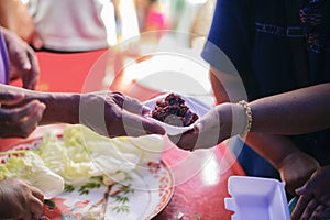 Poor people receiving food from donations : Homeless people are helped with food relief, famine relief : volunteers giving food to