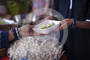 Poor people receiving food from donations : Homeless people are helped with food relief, famine relief : volunteers giving food to