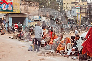 Poor people waiting for charity distributing food on the dirty streets of indian city