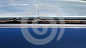 Poor-quality car body repair. The putty is peeling off the metal. Large cracks on the roof of the vehicle