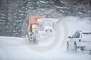 Poor road visibility of a car driving right behind a snow plow during winter road maintenance